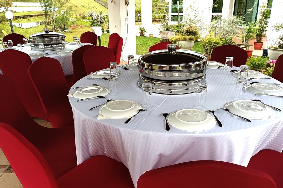 Elegant round table setting with a chafing dish centrepiece at a catered event