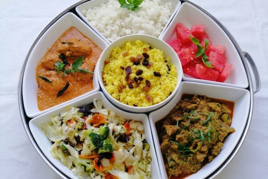 Madli's catering set platter with fragrant rice, curry, salad and fresh watermelon
